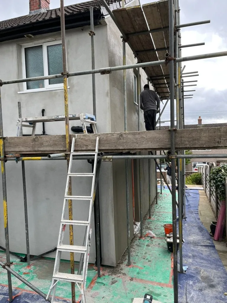 Rendering work progress scaffolding plasterer working
